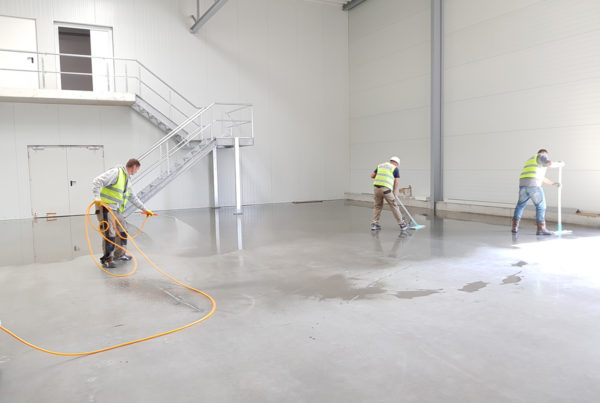 three men cleaning an industrial facility