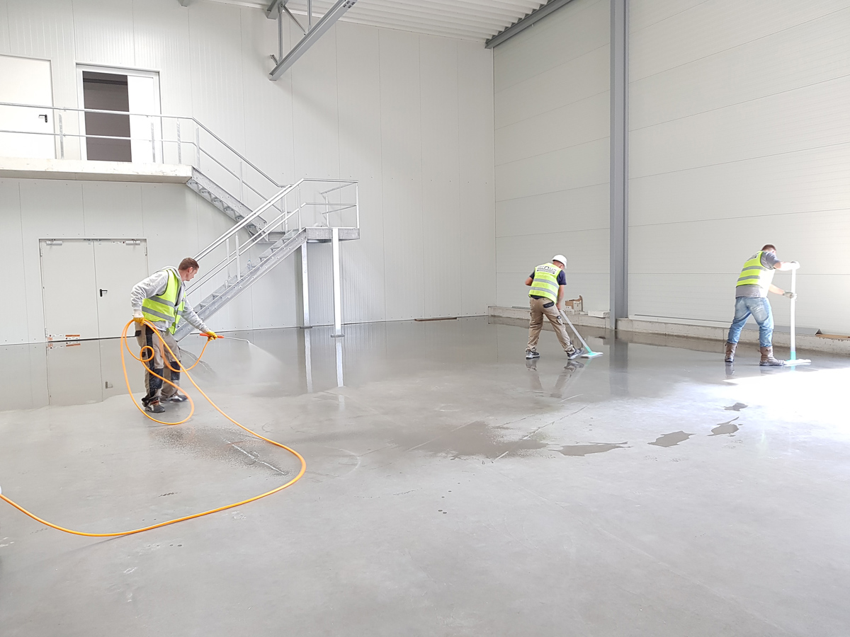 three men cleaning an industrial facility