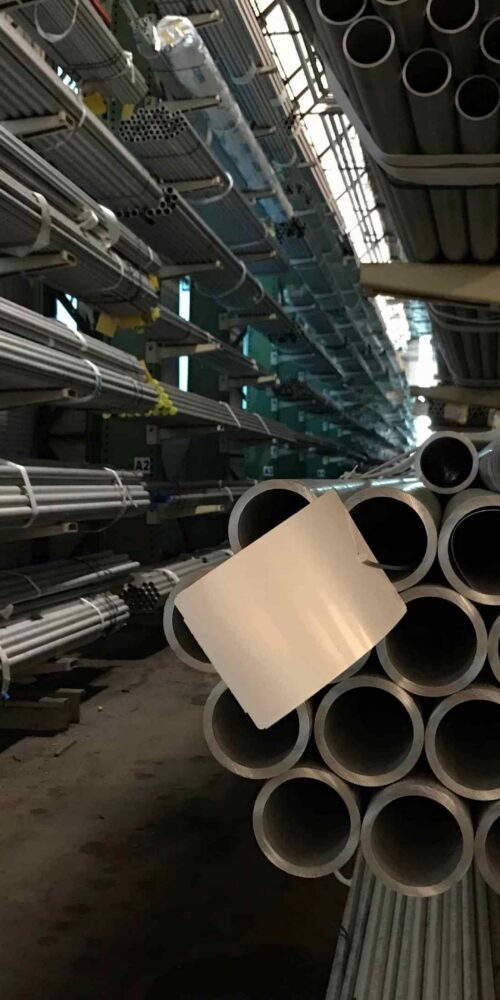 Stainless steel pipe stock stored in an industrial warehouse