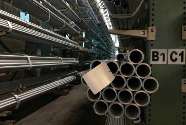 Stainless steel pipe stock stored in an industrial warehouse