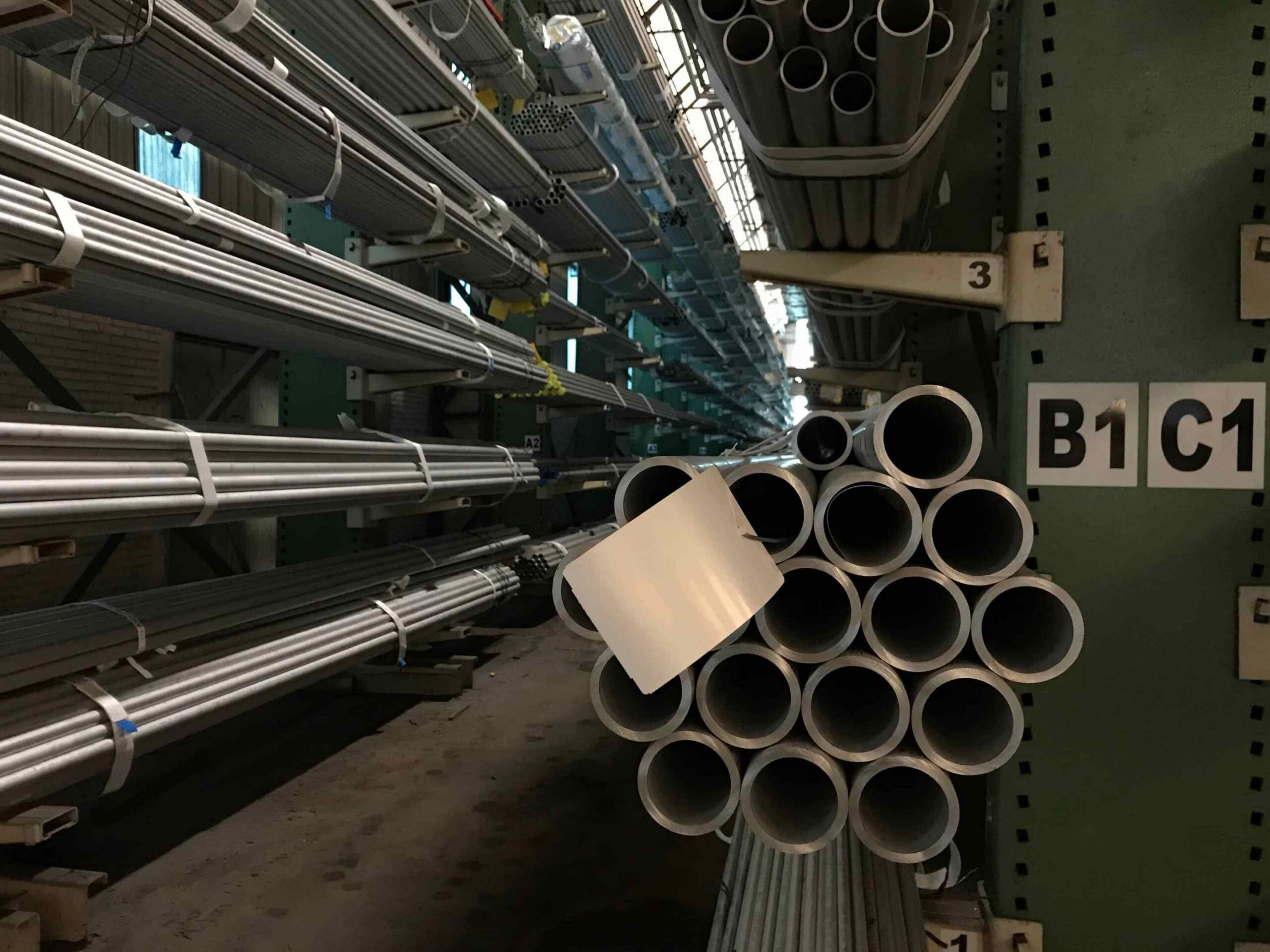 Stainless steel pipe stock stored in an industrial warehouse